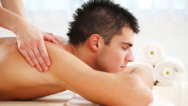 мужчине делают расслабляющий массаж всего тела